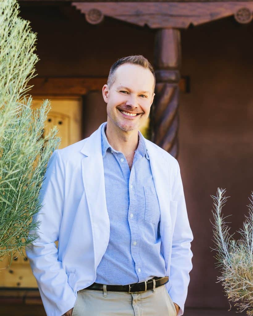 Man in white lab coat outside Golden Crane Acupuncture, representing quality acupuncture care in Las Cruces, NM.
