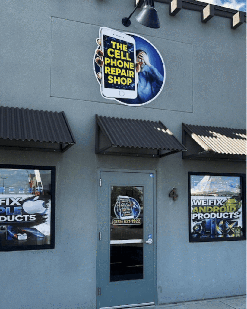 Storefront of a Cell Phone Repair Shop with signage showing a phone and a person, plus window signs advertising Apple and Android repairs.